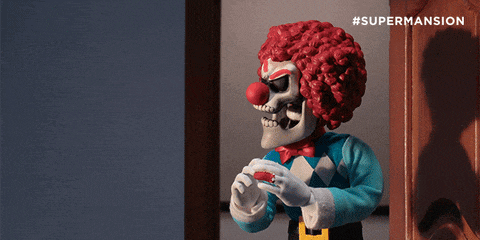 a clown with a red nose is standing in front of a door