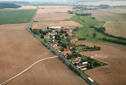 an aerial view of a small village surrounded by fields and houses