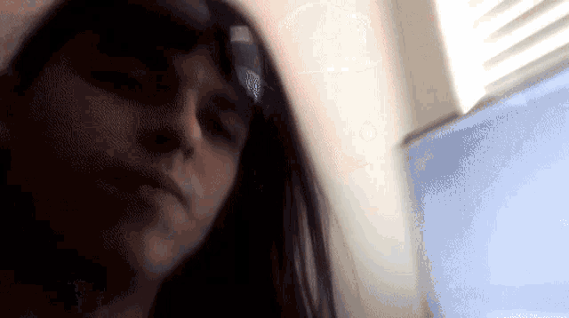 a blurry picture of a woman 's face with a window in the background