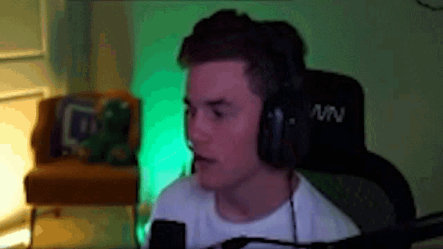 a man wearing headphones is sitting in front of a microphone in a living room .