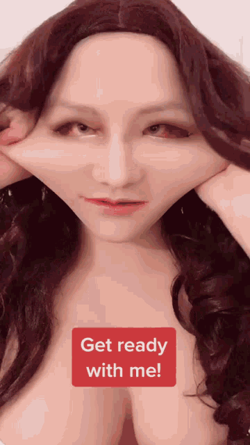 a woman with red hair is making a funny face with a red button that says get ready with me on it