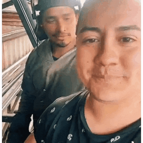 two men are standing next to each other and smiling for the camera .