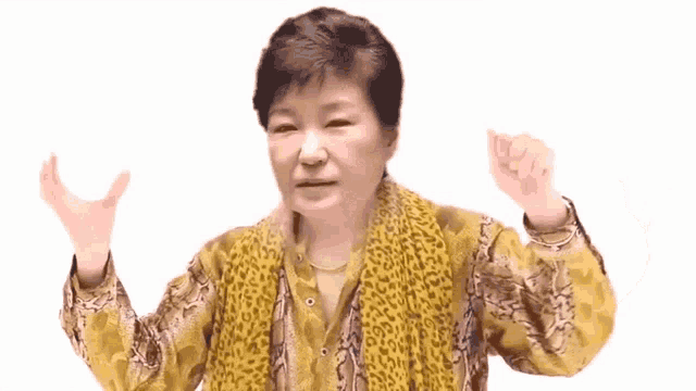 a woman wearing a leopard print scarf and a yellow shirt is making a funny face