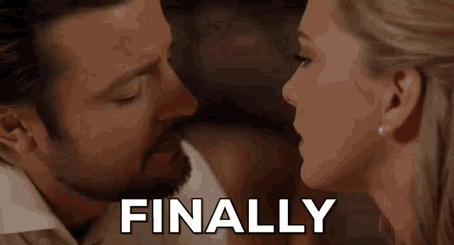 a man and a woman are kissing and the word finally is written above them