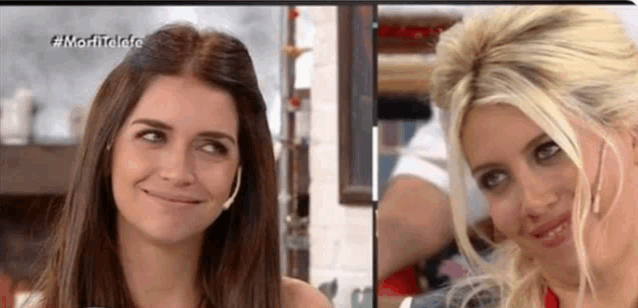 two women are smiling and looking at each other on a television screen