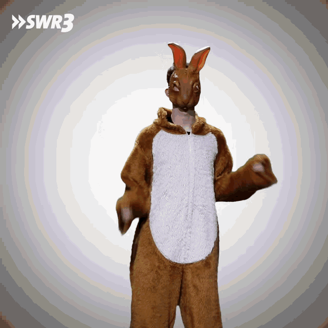 a man in a bunny costume is dancing in front of a swr3 sign