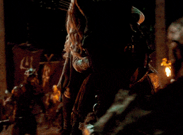 a blurry picture of a woman holding a sword in a dark room