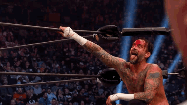 a wrestler with blood on his face is in the ring
