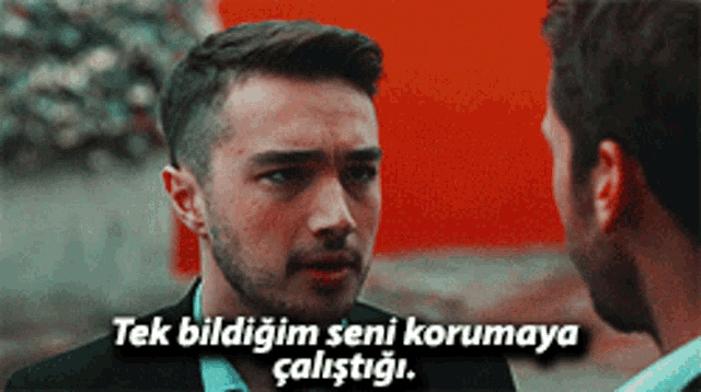 a man with a beard is talking to another man with a caption that says " tek bildigim seni korumaya calistigi "