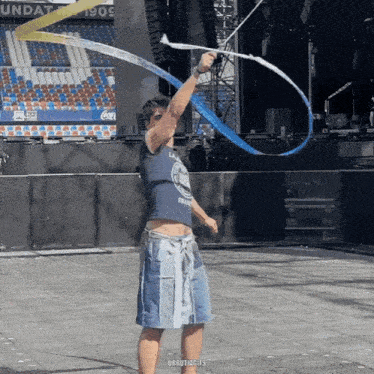 a man in a tank top and shorts is holding a blue and yellow ribbon