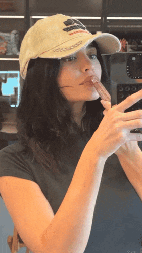 a woman wearing a hat is taking a picture of herself in a mirror
