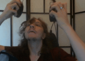a woman with long hair is holding a pair of headphones