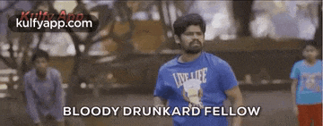 a man in a blue shirt is running in a park with a group of children .