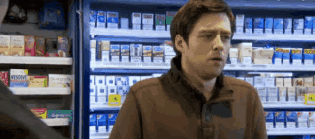 a man is standing in front of a shelf of cigarettes