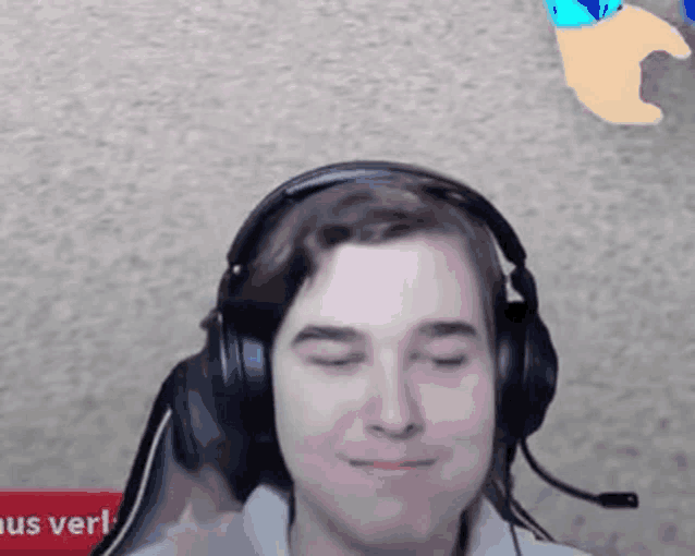 a man wearing headphones and a microphone is making a face .
