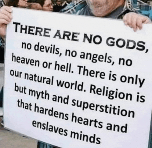 a man holding a sign that says there are no gods