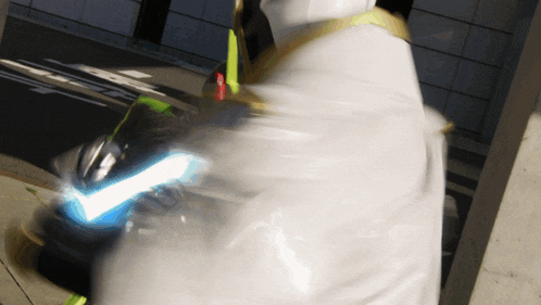 a blurred image of a person holding a sword with a blue light coming out of it