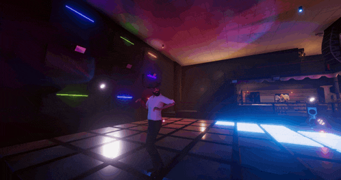 a man in a white shirt is dancing on a dance floor in a club