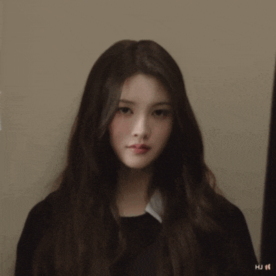 a woman with long brown hair is wearing a black shirt that says hu on it