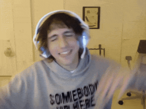 a man wearing headphones and a hoodie that says " somebody " on it