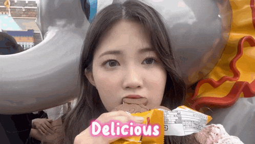 a girl is eating a snack and the word delicious is on the bottom