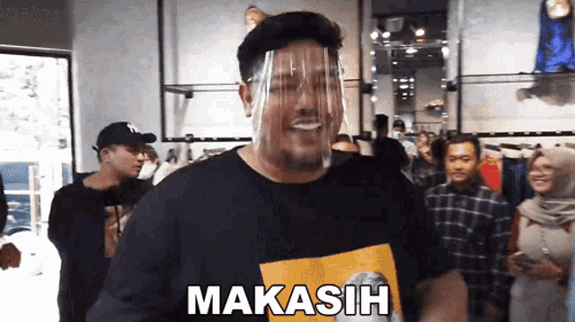 a man wearing a face shield and a shirt that says " makasih "