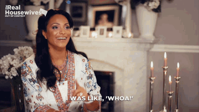 a woman is sitting in front of a fireplace with candles and says i was like whoa