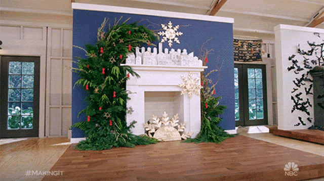 a living room with a fireplace decorated for christmas with a nbc logo in the corner