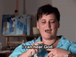 a woman says " i can hear god " in front of an easel