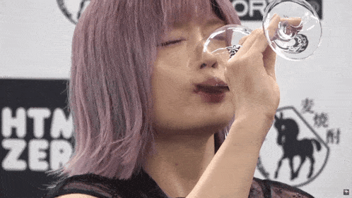 a woman with purple hair is drinking from a glass with a horse on it in front of a sign that says htcer