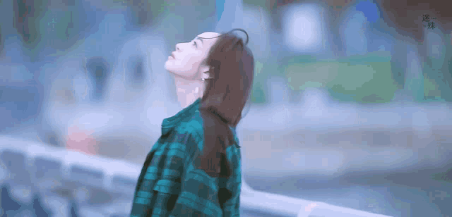 a woman in a plaid shirt is looking up