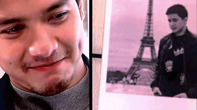 a man is looking at a picture of the eiffel tower and smiling