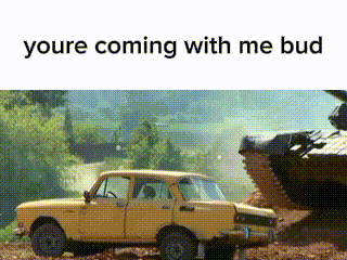 a yellow car is parked in the dirt next to a large tank .