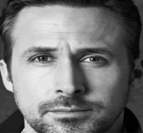 a close up of a man 's face with a beard looking at the camera