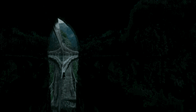 a train is going over a bridge with mountains behind it