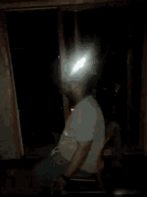 a man in a white shirt with the number 24 on it is dancing in a dark room .