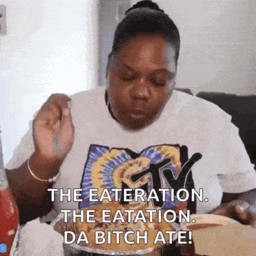 a woman wearing a mtv shirt is eating