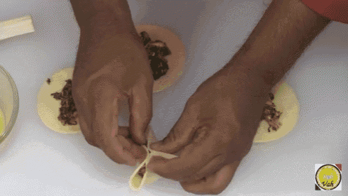 a close up of a person 's hands making a taco with a chef 's dash logo in the background