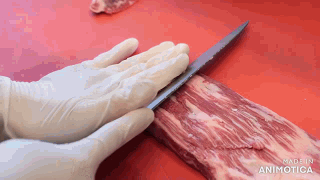 a person wearing white gloves is cutting a piece of meat with the words made in animatica visible in the corner