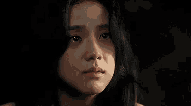 a close up of a young girl 's face with a tear running down her cheek .