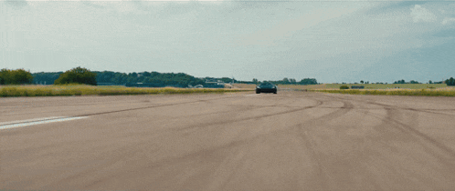 a car is driving down a dirt road