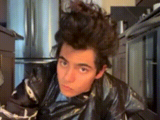 a young man with a mohawk looks at the camera