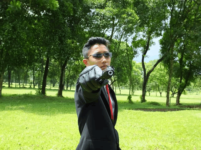 a man in a suit and tie is pointing a gun