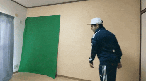 a man is standing in front of a green screen .