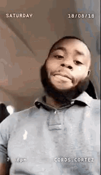 a man with a beard is making a funny face while looking at the camera .