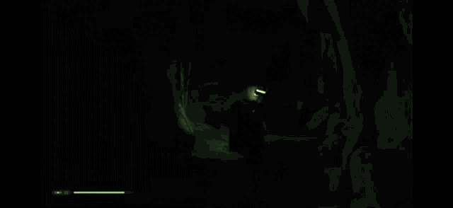 a person is holding a green lightsaber in a dark room .