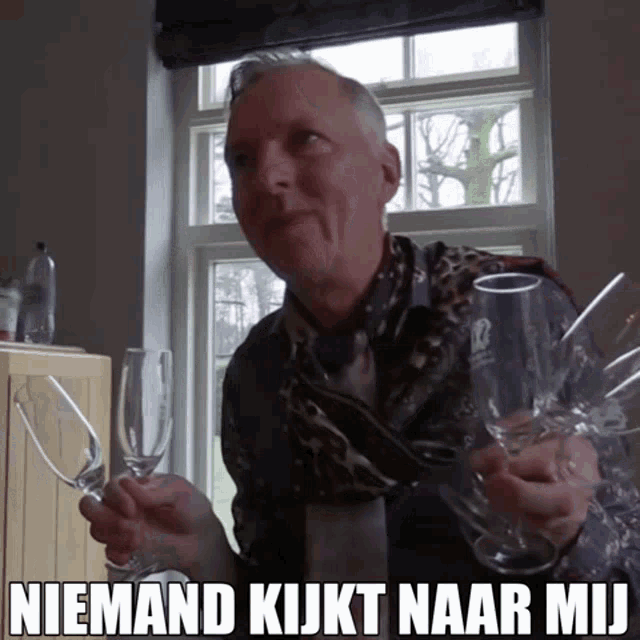 a man in a leopard print shirt is holding empty wine glasses with the caption niemand kijkt naar mij