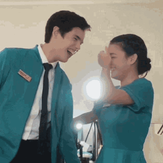 a man and a woman are standing next to each other and laughing together