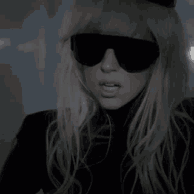 a close up of a woman wearing sunglasses and a top hat