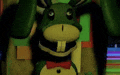 a green and yellow stuffed animal with a bow tie is standing in front of a green wall .